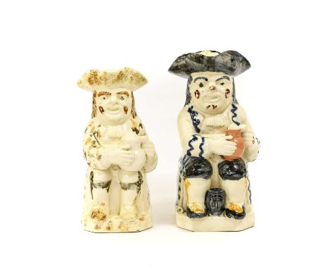 A Prattware Toby Jug, circa 1800, of traditional form, sitting holding a jug of ale, a barrel between his feet, his pipe at h