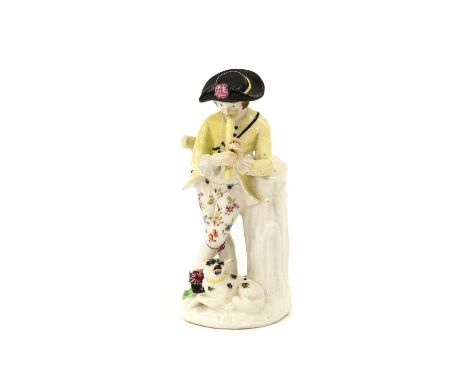 A Bow Porcelain Figure of a Shepherd, circa 1758, leaning against a tree trunk playing a pipe, his dog at his feet15.5cm high