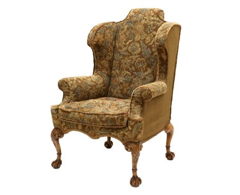 A George III Chippendale-Style Wing-Back Armchair, late 19th century, covered in brown and floral moquette, the squab cushion