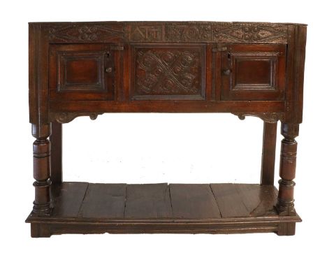 An Early 18th Century Joined Oak Livery Cupboard, dated 1708 and initialled ATT, the boarded top above a carved frieze and ce