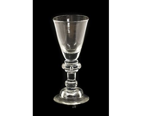 A Wine Glass, circa 1720, the funnel bowl on an annulated knop and plain stem with basal knop on a domed foot15cm highNo chip