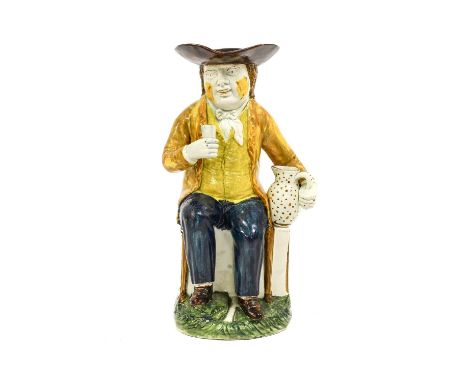 A Prattware Sailor Toby Jug, circa 1795, modelled sitting on a high-back chair, a jug in one hand, a beaker in the other30cm 