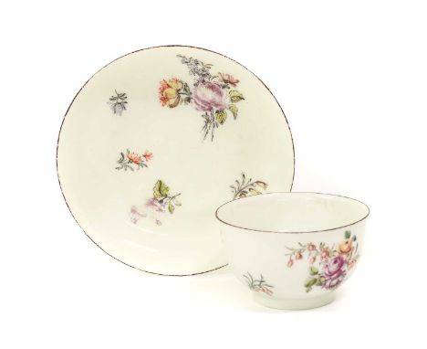 A Chelsea Porcelain Tea Bowl and Saucer, circa 1755, painted with flowersprays and scattered sprigs within brown line borders