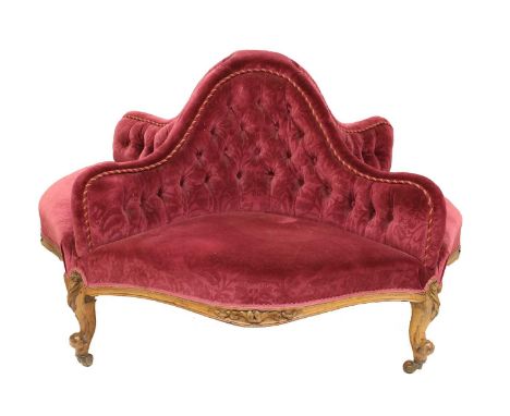 A Victorian Walnut-Framed Four-Seater Conversation Sofa, circa 1870, recovered in red floral buttoned velvet, the serpentine 