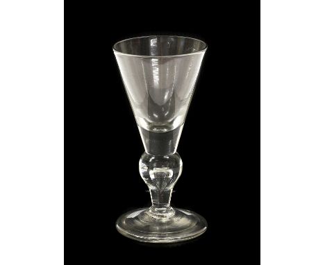 A Heavy Baluster Wine Glass, circa 1710, the conical bowl with solid base on an inverted baluster stem with air tear and fold