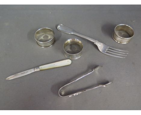 Three silver napkin rings, a silver fork, silver nips and a silver bladed fruit knife total weighable silver approx 3 troy oz