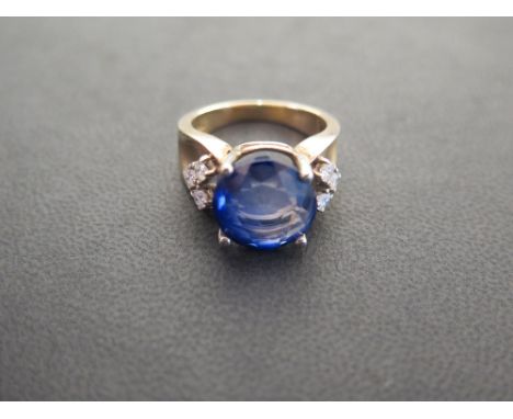 A 9ct gold sapphire and diamond dress ring - The circular sapphire (13.3mm), to the brilliant-cut diamond trefoil shoulders a