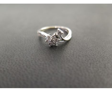 A diamond dress ring - The diamond floral cluster and leaf to the asymmetric shoulders and plain band - Stamped 750 - Ring si