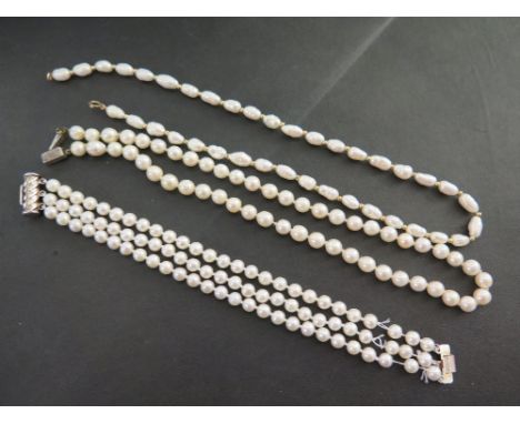 A freshwater cultured pearl necklace - Clasp stamped 9K - Length 47cms - Together with a cultured pearl three-row bracelet an