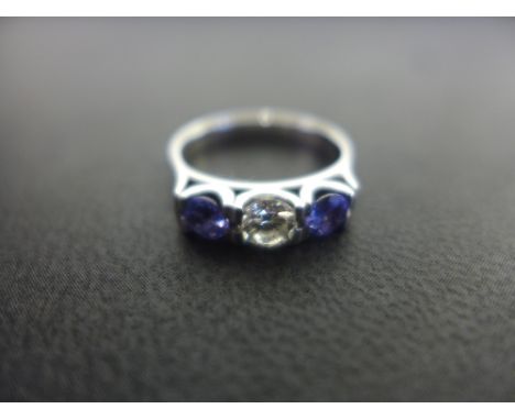 A tanzanite an diamond three-stone ring - Estimated diamond weight 0.35ct - Stamped 750 - Ring size M - Weight approx 4.1gms
