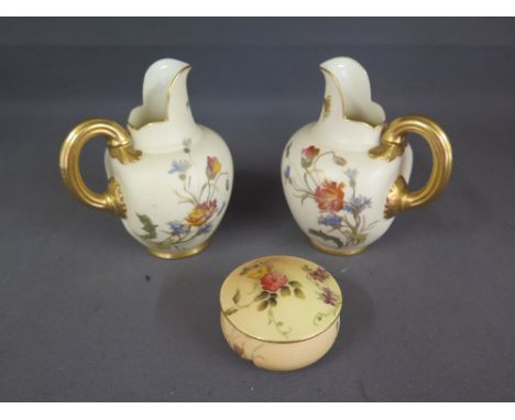 A pair of Royal Worcester blush ivory jugs - Height 13 cm - both in good condition and a lidded trinket pot - in good conditi