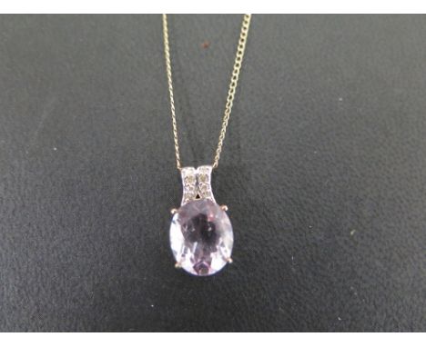 A 9ct gold amethyst and diamond pendant - Hallmarked Birmingham - Length 1.8cms - Suspended from a curb-link chain - Stamped 