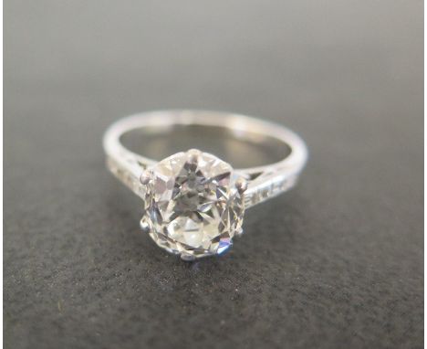 An early 20th century platinum diamond ring - The old-cut diamond to the baguette-cut diamond shoulders and plain half-band -