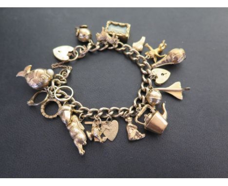 A 9ct gold curb-link bracelet suspending an assortment of charms - Partial hallmark - Length 19cms - Weight approx 53.8gms
Co
