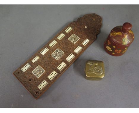 A carved Chinese hardwood and bone cribbage board with intricately carved foliate design set with deeply carved bone plaques 
