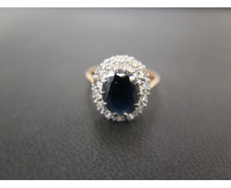 A sapphire and diamond cluster ring - The oval-shape sapphire within a single-cut diamond surround to the plain band - Stampe