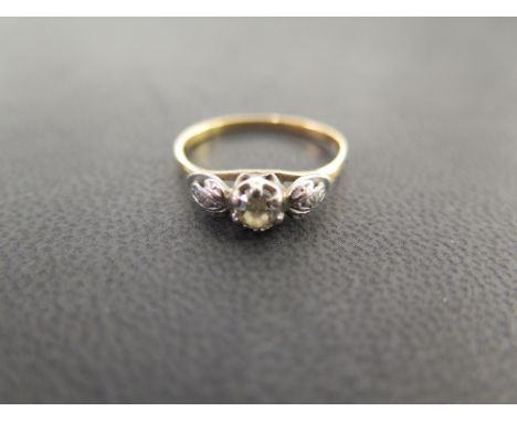 An 18ct gold diamond ring - The brilliant-cut diamond to the textured leaf shoulders and plain band - Estimated diamond weigh