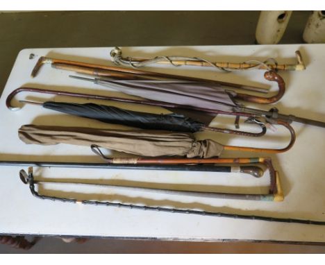 A collection of eleven vintage walking sticks, crops and parasols