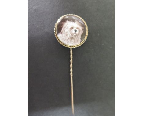 A gold and enamel dog portrait stick pin - the mount and shaft tests as 9 ct gold  - the portrait of the white terrier is ena