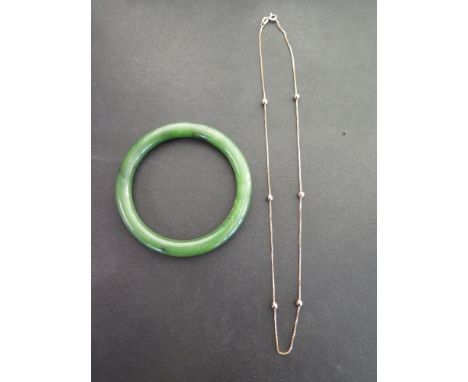 A nephrite jade bangle - Inner diameter approx 6cms - Weight approx 36.3gms - Together with a 9ct gold box-link chain with go