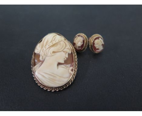 A 9ct gold shell cameo brooch - Length 3.6cms - Together with a pair of similar earrings - Length 1.2cms - Hallmarked London 