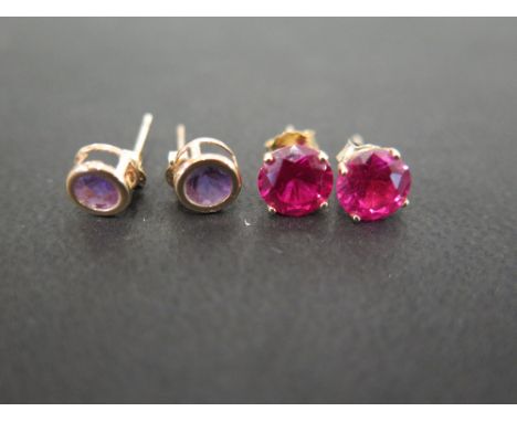 A pair of amethyst ear-studs - Stamped 375 - Weight approx 0.5gm - Together with a pair of synthetic ruby ear studs - Stamped