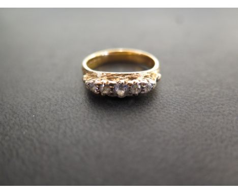 A 22ct gold diamond ring - The graduated old-cut diamonds to the textured surmount and plain band - Estimated total diamond w