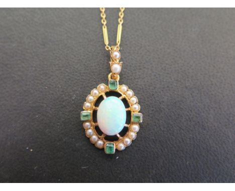 An opal, emerald and seed pearl pendant - Suspended from a fancy-link chain - Stamped 15ct - Length of pendant 3.2cms - Lengt