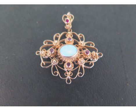 A 9ct gold opal and ruby pendant/brooch - Hallmarked London - Length 4.5cms - Weight approx 7.6gms
Condition Report: Good 