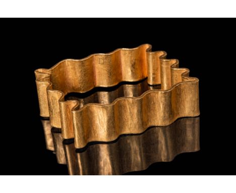 Ca. 10th - 12th century AD. A solid gold bracelet with an undulating, rectangular form composed of a continuous sheet folded 