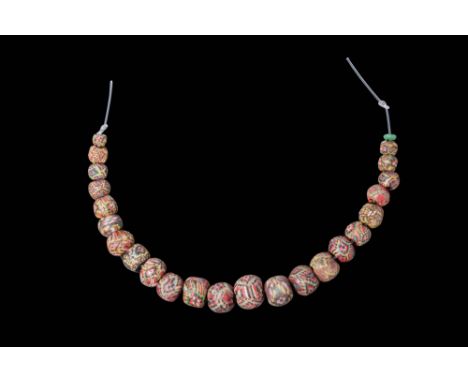 Ca. 100 BC - AD 100 .A string of 23 mosaic glass beads in varying sizes and shapes, predominantly spherical and slightly obla