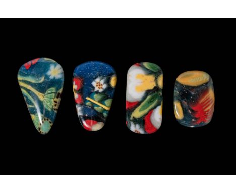 Ca. 332 BC - AD 200. A collection of four mosaic glass inlays with floral motifs. Each piece has rounded edges and depicts st