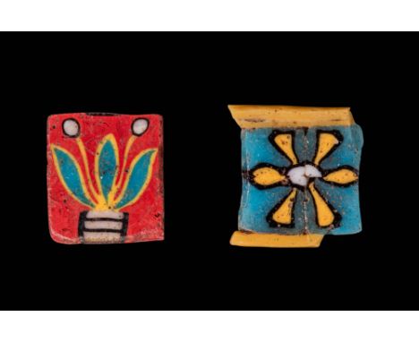 Ca. 100 BC - AD 100.A pair of rectangular glass inlays. The first on the left has a red background featuring a stylised lotus