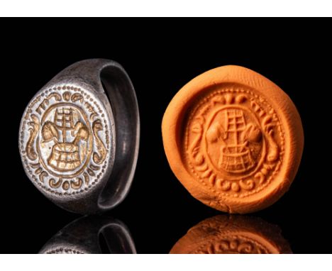 Ca. AD 1200 - 1400.A silver merchant's seal ring with a flat sectioned round hoop that enlarges on the shoulders to form a ro
