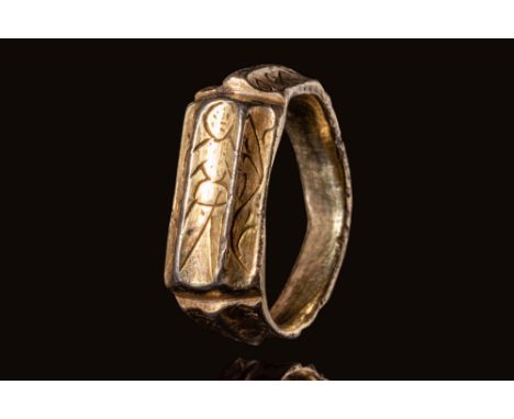 Ca. AD 1400 .A rare British Medieval silver gilt iconographic ring with a round hoop. On the hoop sits a ridged shoulder, emb