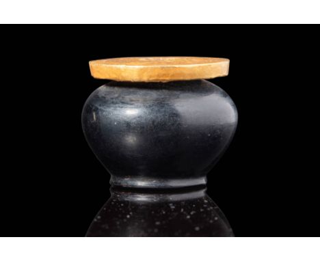 12th - 19th Dynasty, Ca. 1938 - 1190 BC. A small stone vessel with a rounded body that narrows towards a short, flat base. A 