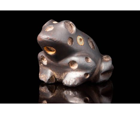 Ca. 2300 - 2000 BC. A haematite weight in the form of a stylised frog, depicted in a crouched position with its forelimbs ben