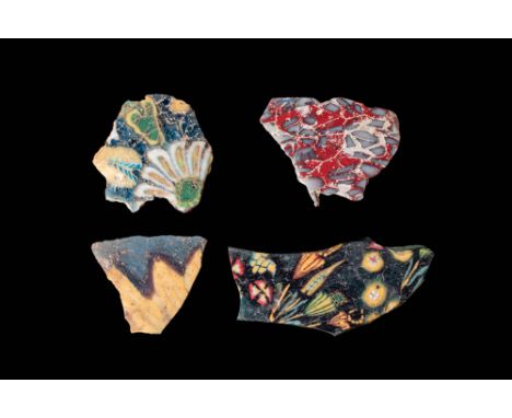 Ca. 30 BC - AD 200. A collection of four fragmentary mosaic glass inlays. The first, in the top left corner, has a blue groun