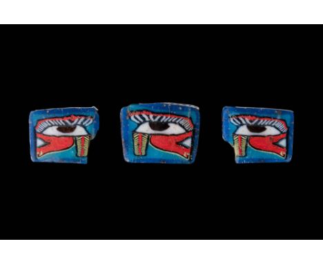 Ca. 100 BC - AD 100. A collection of three rectangular glass inlays depicting the Eye of Horus. Each inlay has a blue ground 