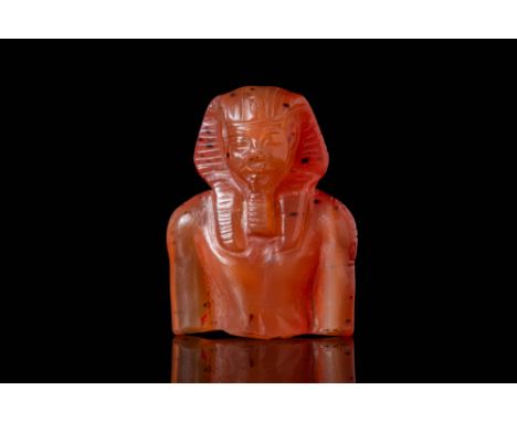 New Kingdom, Ca. 1279 - 1212 BC. A carnelian bust depicting Ramses II wearing a nemes headdress. The face has a rounded foreh