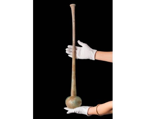 Ca. AD 1 - 300.A translucent green glass bottle with an apple-shaped body and an exceptionally long neck ending in a flared r