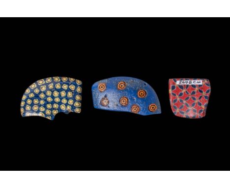 Ca. 332 BC - AD 200. A collection of three glass inlays with geometric and floral designs. The first, a curved fragment, has 