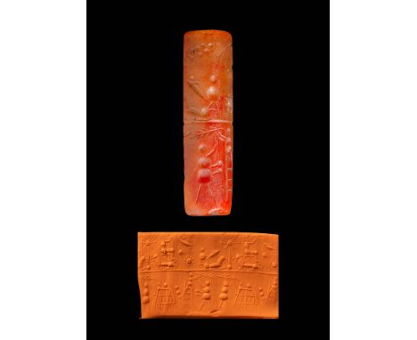 Ca. 1000 - 500 BC. A carnelian seal of cylindrical form, pierced longitudinally. The upper section features a seated figure o