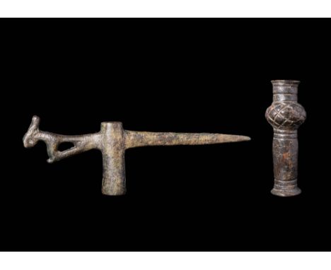 Ca. 2500 - 900 BC.A pair of bronze weapons. The first is a pick axe featuring a socketed tubular body, with a long, tapered, 