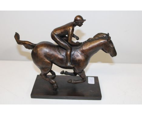 A bronze figure of a racehorse with jockey. 31cm x 26cm 