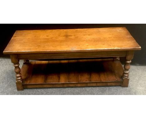 Rectangular oak coffee table, over sailing top above turned baluster columns, shelf under tier, 122cm x 56cm 