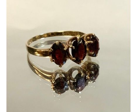 A garnet trilogy ring, graduating oval, deep reddish brown garnets, 9ct gold shank, size P, 1.9g gross 