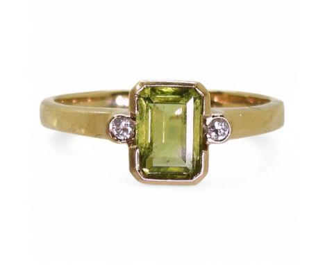 A 9ct gold peridot and diamond ring, set with a step cut peridot of approx 7mm x 5mm, and two 0.025ct brilliant cut diamonds,