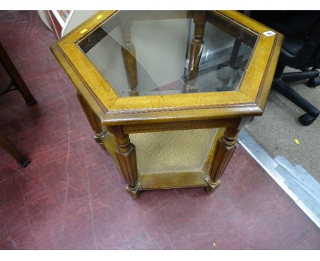 Modern rectangular occasional table with glass top and cane lower shelf and a modern black office chair