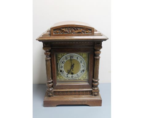 An antique mahogany cased German mantel clock with brass dial 